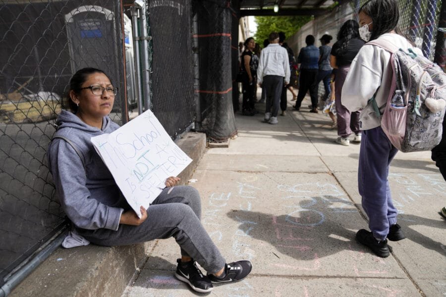 Una manifestante fuera de la escuela pública 172 mientras los estudiantes salen de clases, el martes 16 de mayo de 2023, en Nueva York. (AP Foto/John Minchillo)