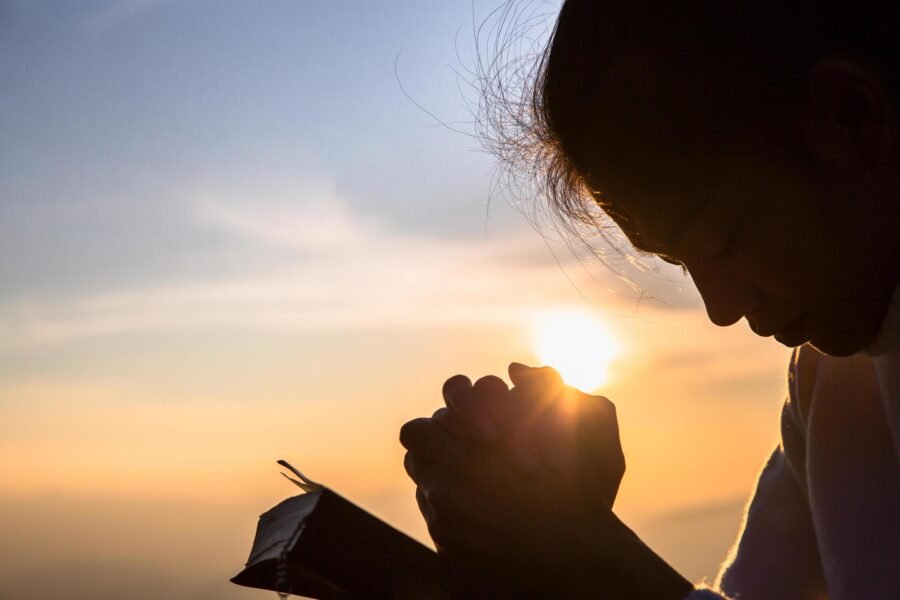 silhouette-of-christian-young-woman-praying-with-a-cross-and-open-the-bible-at-sunrise-christian-religion-concept-background-free-photo